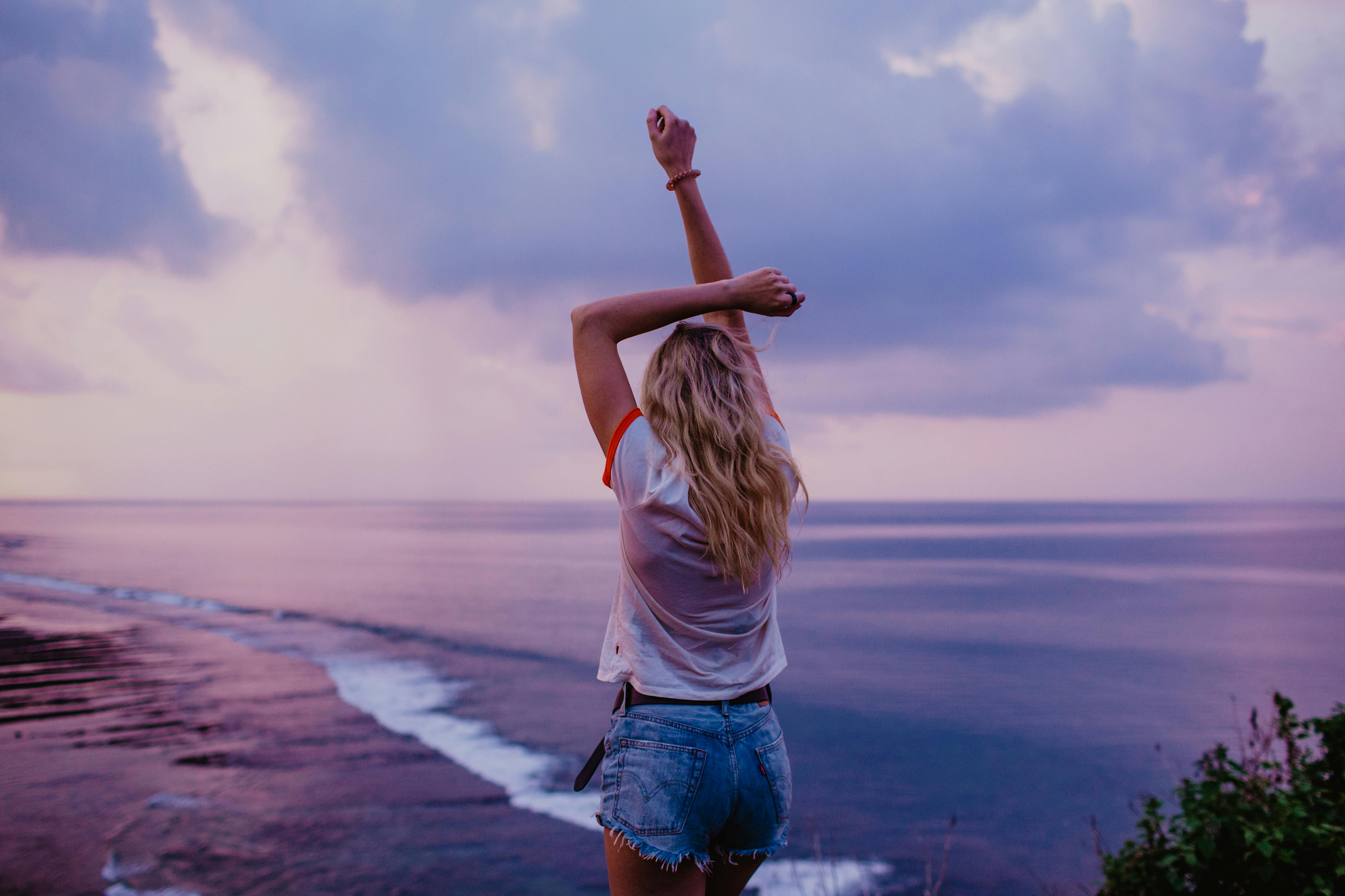 A woman on a beach overlooking a purple sunset