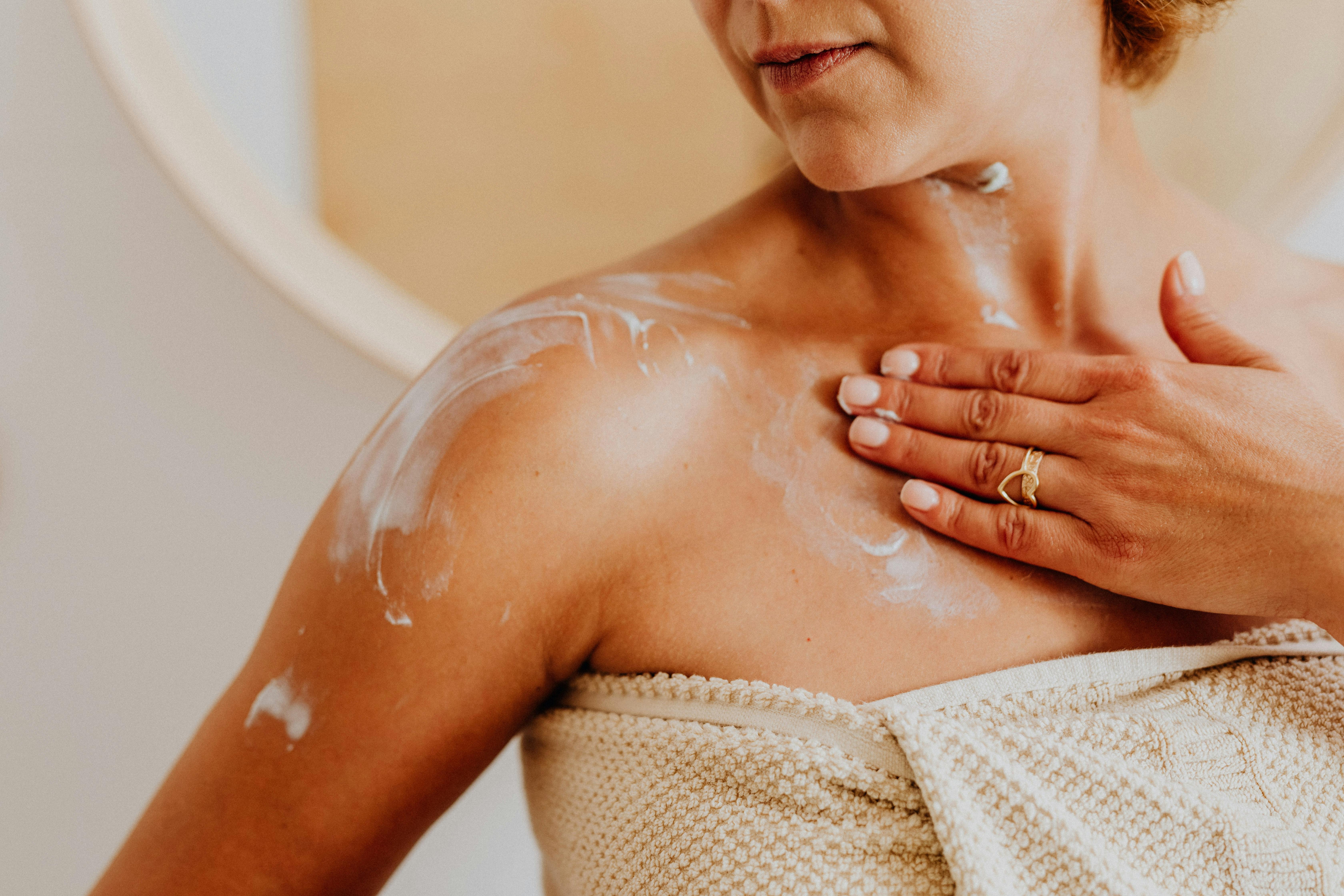 a woman applys cream to her hands